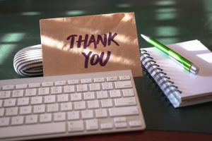 Thank you note and keyboard on desk