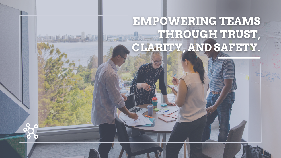 What Role Do Managers Play in Creating a Collaborative and Safe Environment for Employees Group of people standing around a table in an office for a meeting