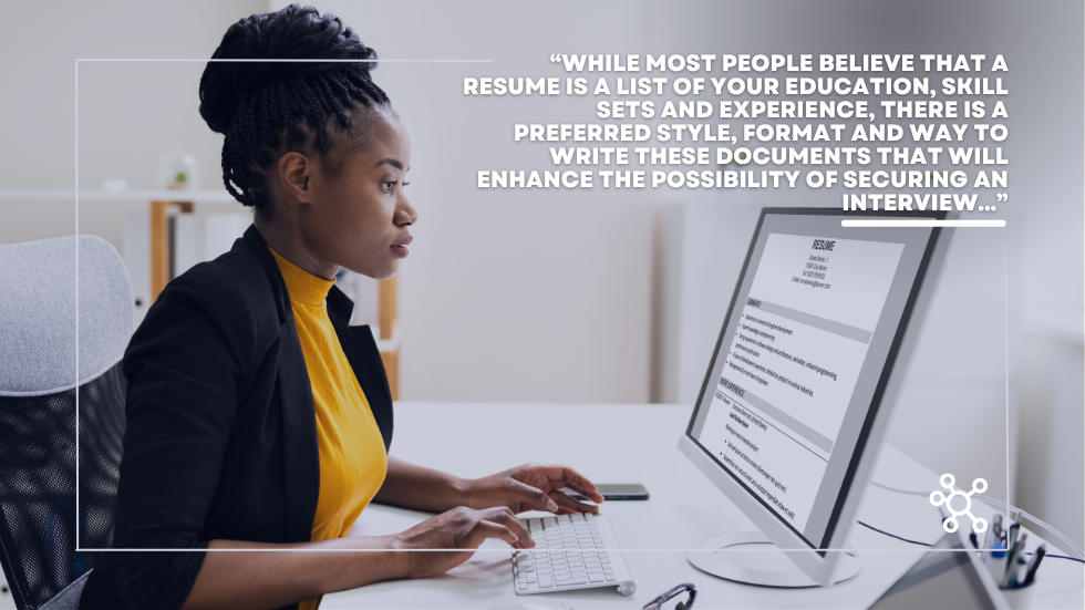 Woman looking intently into resume on computer and typing