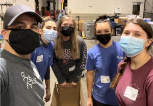 5 people with masks working in a food bank