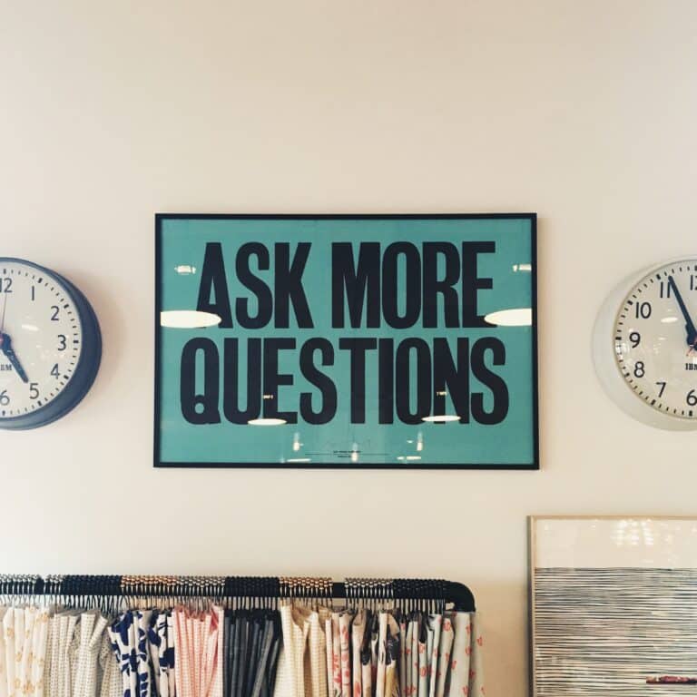 teal sign on wall saying ask more questions