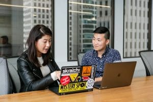 two people looking at an open laptop