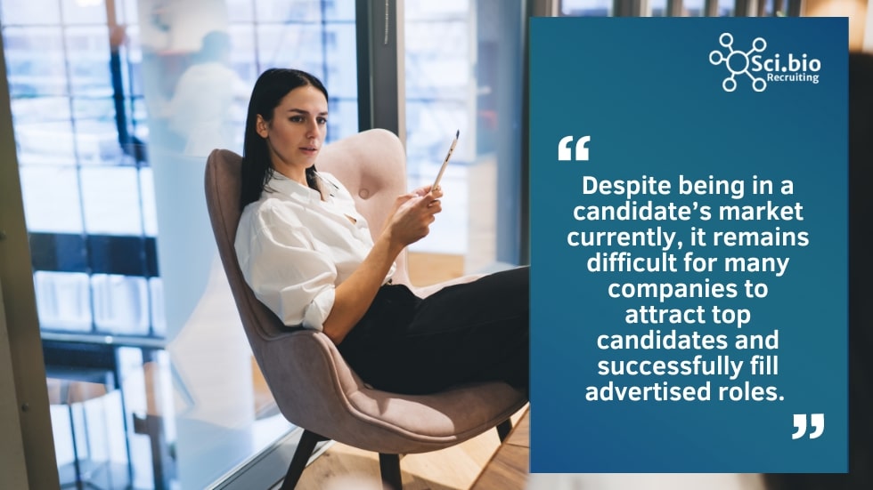 woman sitting in a chair with pencil held in the air for fill a job vacancy