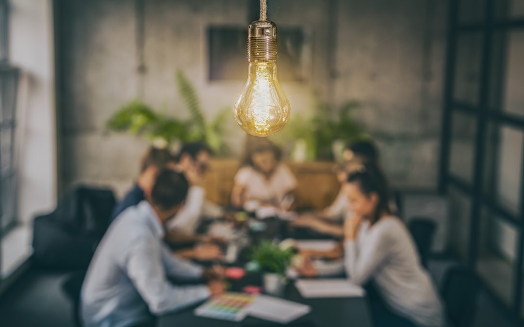 group of people gathered around a table having a meeting