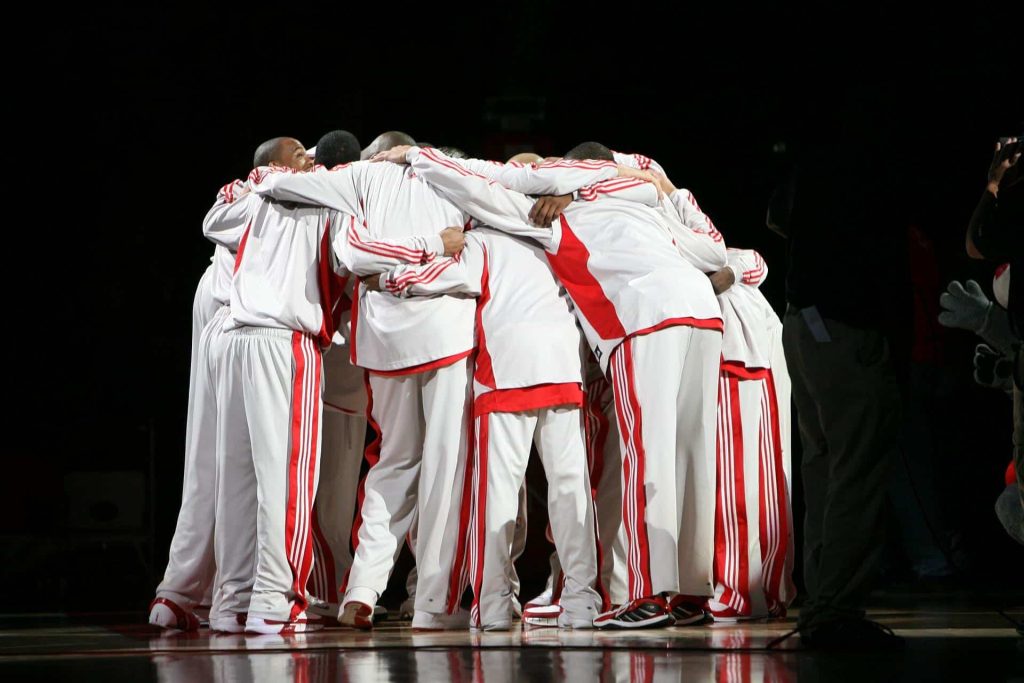 people in white and red suits in huddle